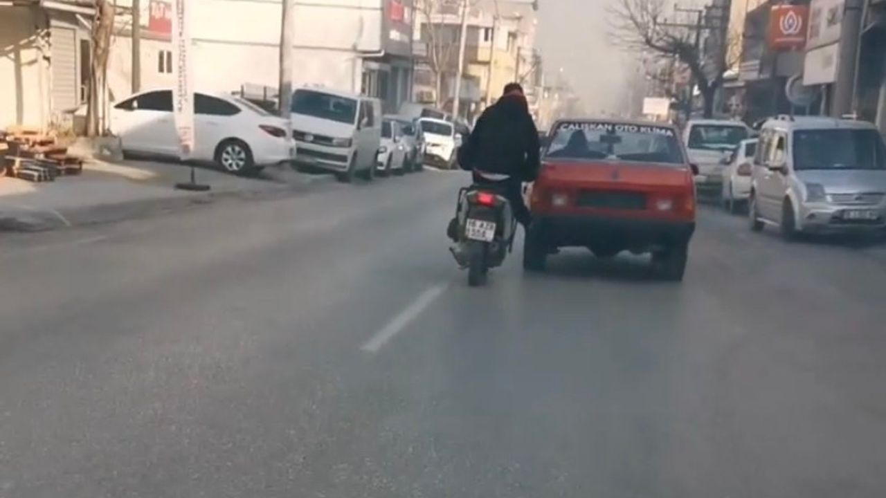 Bursa'da bozulan otomobili motosiklet ile itti